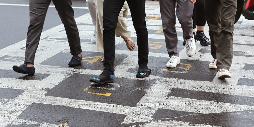 Group of people crossing a busy street. If you have been injured, call our pedestrian accident lawyers in Kansas City, MO.